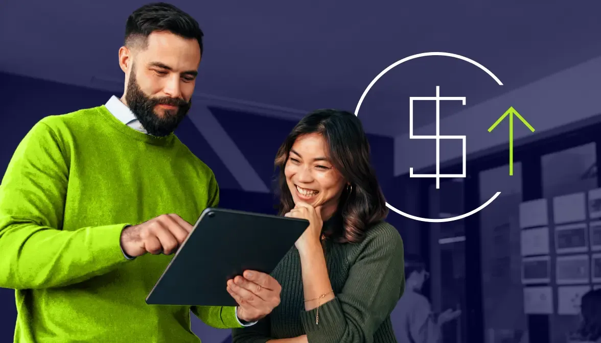 Business professionals reviewing tablet with upward trending dollar sign icon in modern office