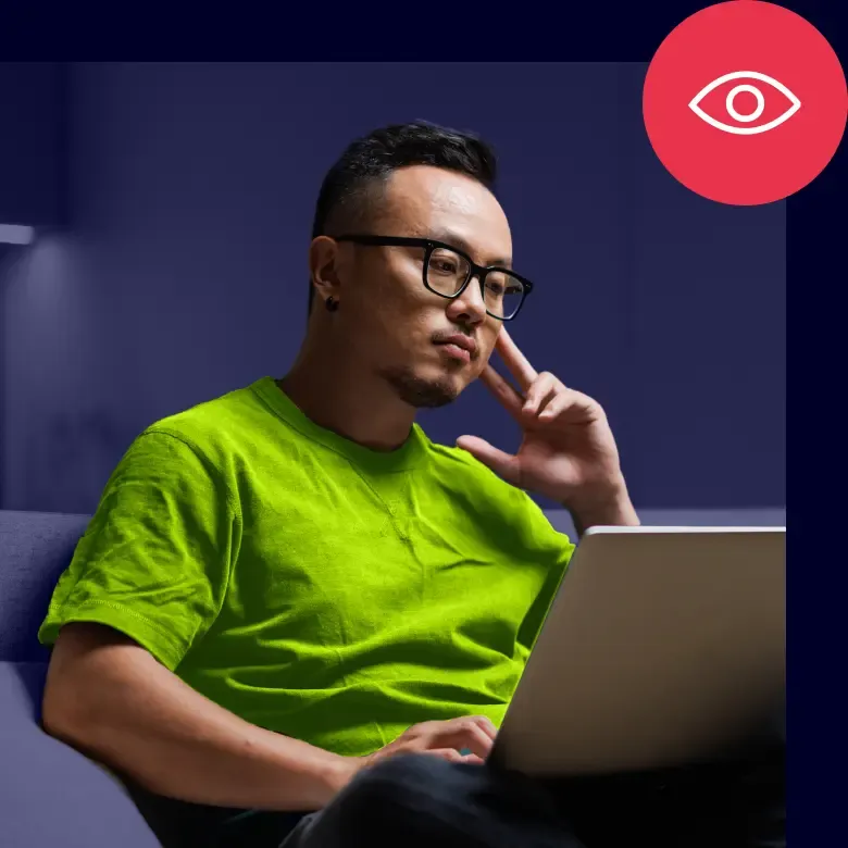 Person using laptop with icon representing detection monitoring visibility