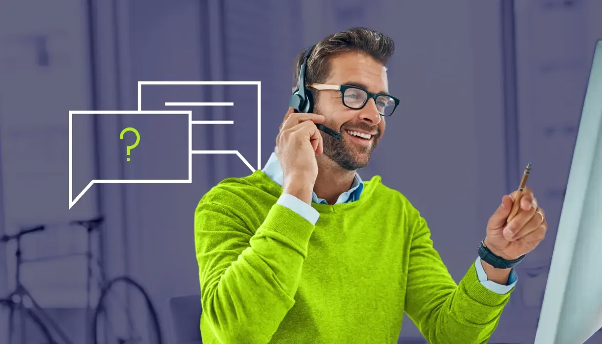 Customer service representative wearing headset smiling while gesturing with chat bubble icons beside him