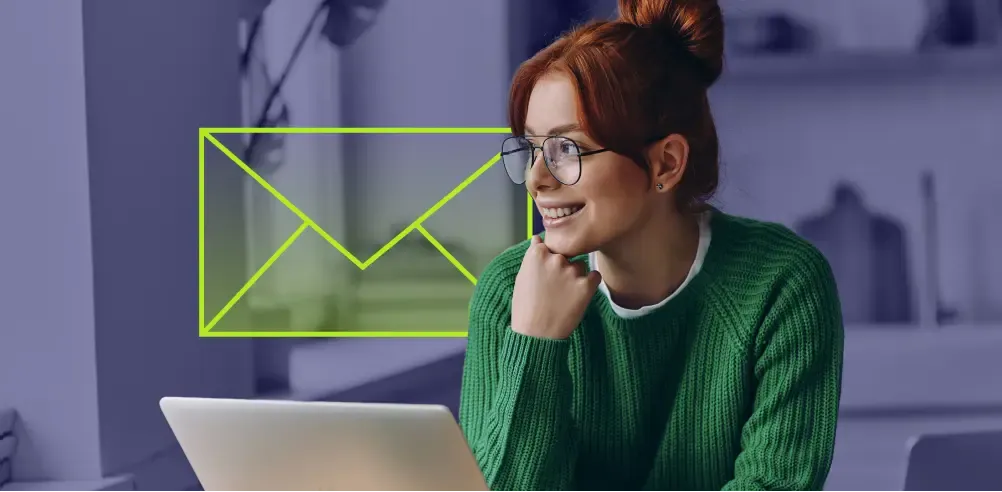 Professional smiling at laptop with email icon overlay