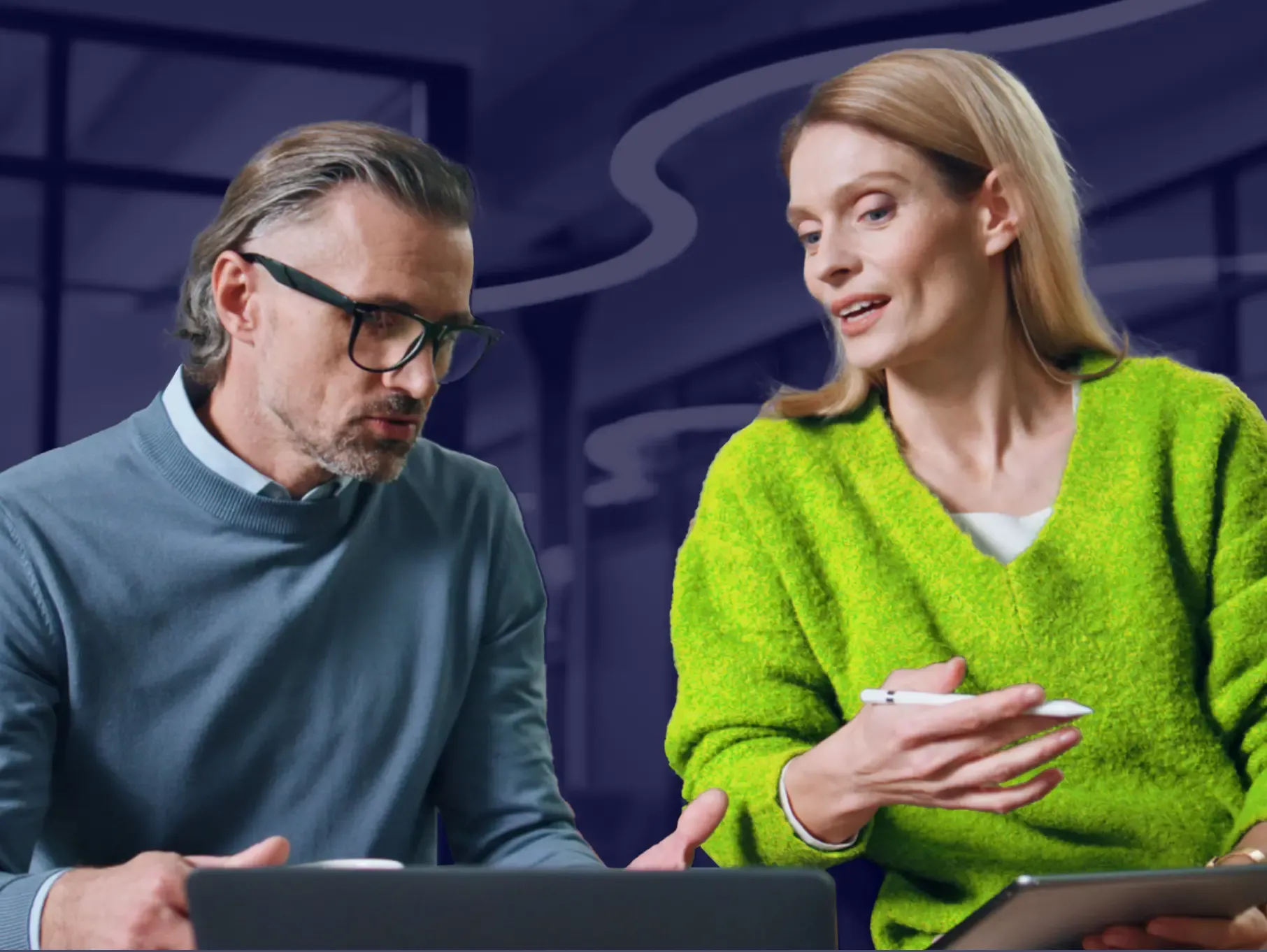 Two colleagues reviewing cybersecurity on mobile device in bright workspace
